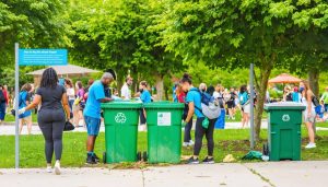 Community members of different ages and backgrounds participating in a clean-up event in a park focused on recycling vape products and promoting sustainable vaping practices.